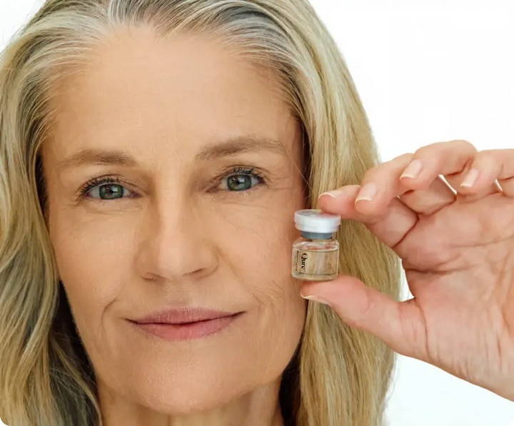 Woman holding anti-aging serum vial