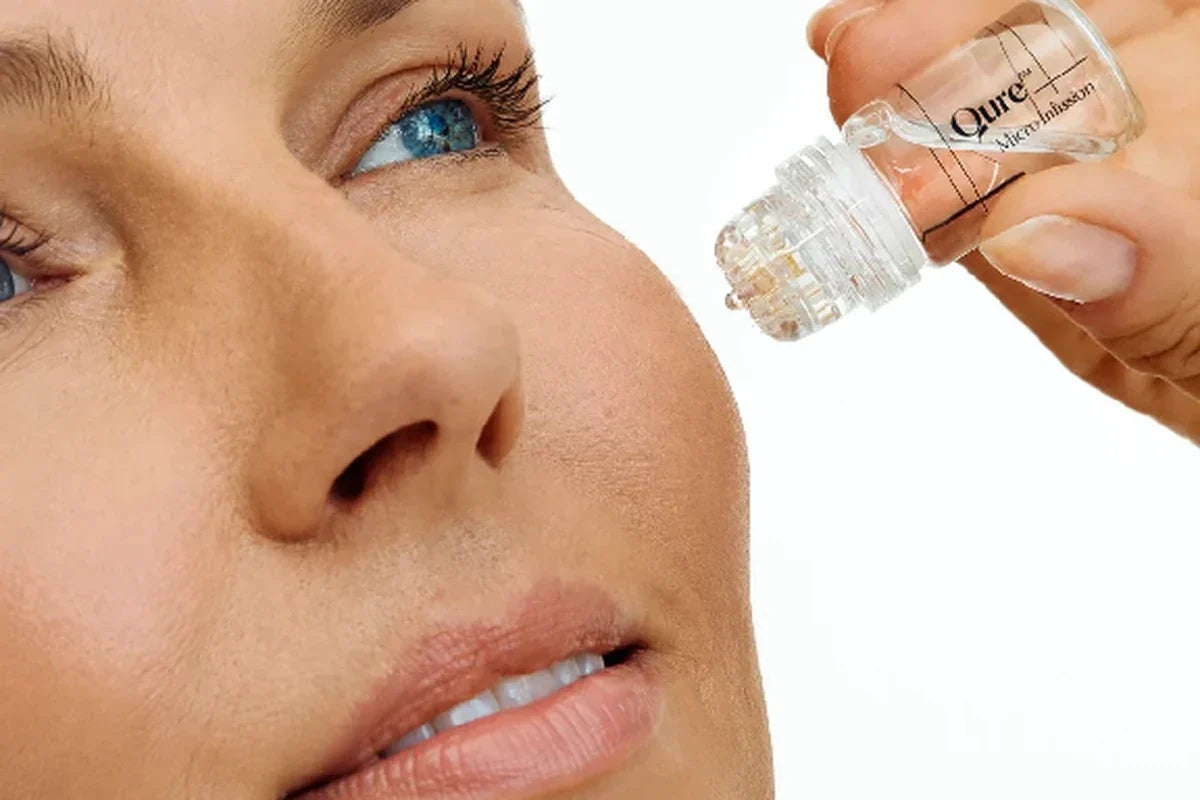 Close-up of a microneedling device held near a woman's cheek