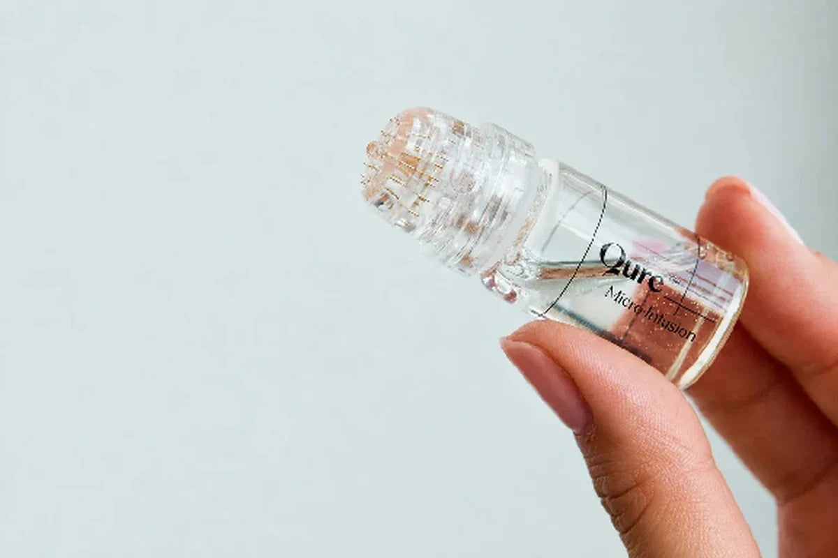Qure Micro Infusion skincare device held in hand