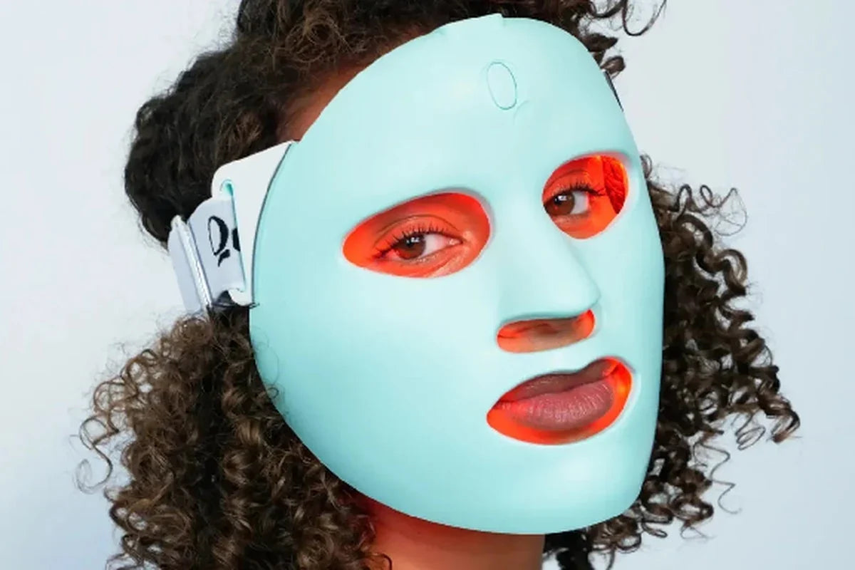 Person wearing a glowing red light therapy face mask