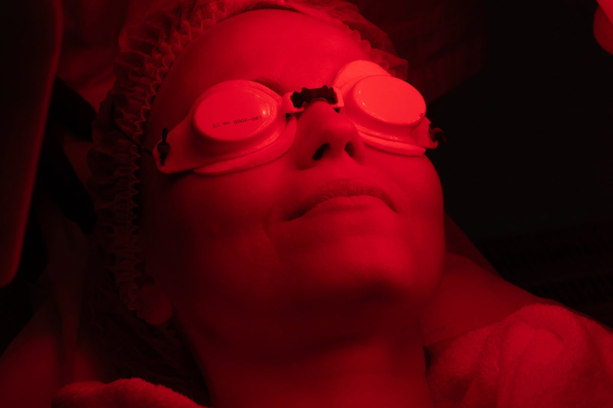 Closeup of woman doing red light therapy and wearing goggles as part of a discussion on whether you need goggles for red light therapy