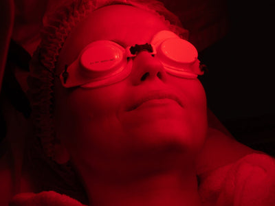 Closeup of woman doing red light therapy and wearing goggles as part of a discussion on whether you need goggles for red light therapy