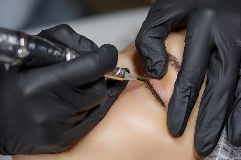 Tattoo artist tattooing permanent eyeliner, raising the question, does red light therapy affect tattoos?