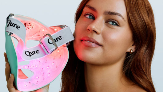Woman holding the Q-Rejuvalight Pro, one of the best led face mask for wrinkles options, with red lights visible inside the mask