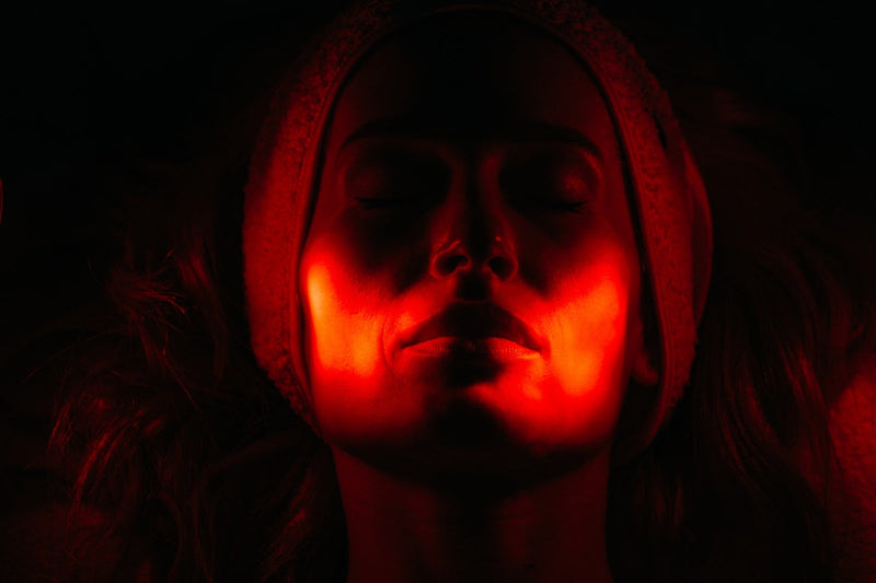 Woman undergoing red light therapy, comparing qure led mask vs dr dennis gross options for at-home skin treatment