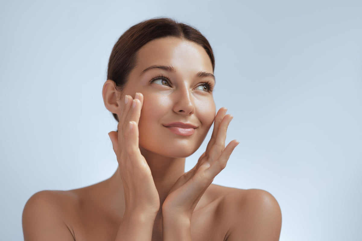 Woman with glowing skin gently touching her cheeks comparing Qure vs Seranova