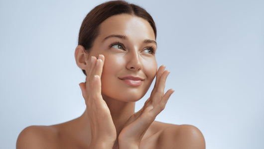 Woman with glowing skin gently touching her cheeks comparing Qure vs Seranova