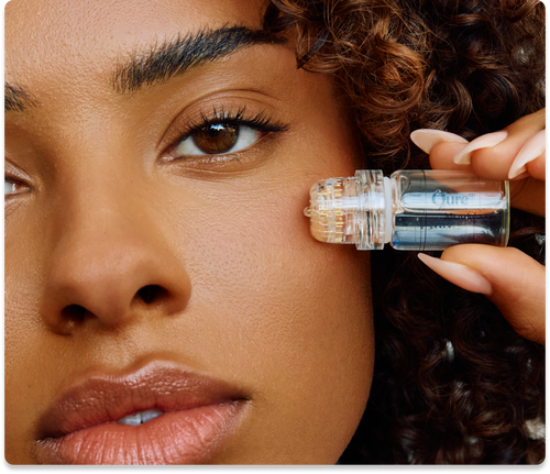 Person using a skincare device on their cheek.